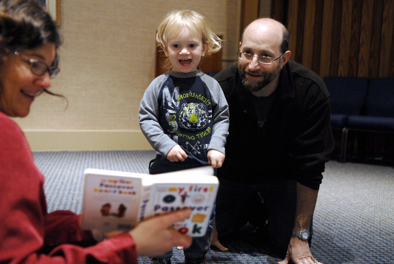 Agustin Wachs, age 1, listens to the Passover story as read by Elana Salzman with his father, Juan Wachs, during Parent-Tot Time on Sunday, March 17, 2013, at Temple Israel in West Lafayette. Passover, which celebrates the story of the Israelites\' escape from Egypt, began at sunset on March 25.