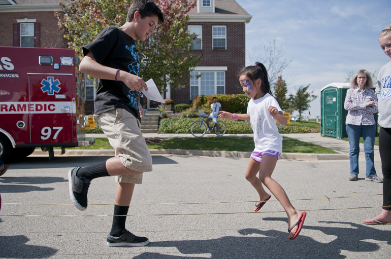 Fishers High School sophomore German student Ben Bertling teaches a rope dance to Ellie Seok, 8, during Fishers Oktoberfest at Saxony, Saturday, Sept. 28, 2013.