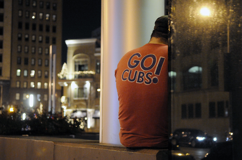 A Scotty's Brewhouse patron looks at his phone as the back of his Cubs shirt faces Pennsylvania Street in Indianapolis, Nov. 30, 2012.