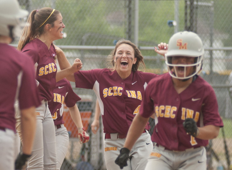Scecina pitcher Julia Blastic (center) and other teammates celebrate as Lea Thompson (right) runs home after Justice Carmichael\'s grand-slam home run during Scecina\'s 7-4 victory over Cathedral in the high school city softball title game at Brookside Park, Saturday, May 9, 2015.