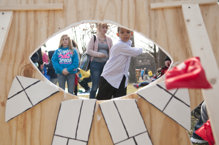 Jashawn Hicks, 6, throws a bean bag through a hole in a wooden tooth cutout during the third annual Ivy Tech Dental Assisting Easter Egg Hunt & Sidewalk Carnival on Saturday, March 30, 2013, at Ivy Tech Community College in Lafayette, Ind. The event raised money for the Judy Buckles Scholarship.