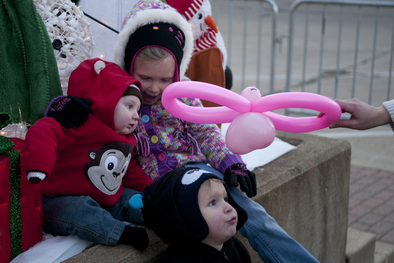 From left, Elliott, Aubriana and Myles Cottrell get ready for a picture as their mother, Angel Cottrell, points a balloon toward them during Christmas on the Square in Danville, Friday, Nov. 29, 2013.