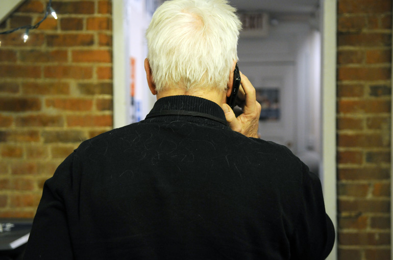 Jay Smith makes a late phone call in the campaign field office as his white hair shows fallen onto his shoulders.