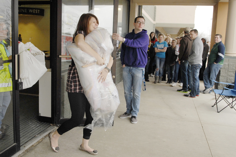 Senior Emily Mann of Delphi High School walks out with a free prom dress during Gown Town on Friday, March 15, 2013, at the Lafayette Market Place. Gown Town, hosted by radio stations WKOA and B102.9, provides free prom dresses for lower-income high school students. Many girls started waiting in line at 2:30 p.m.