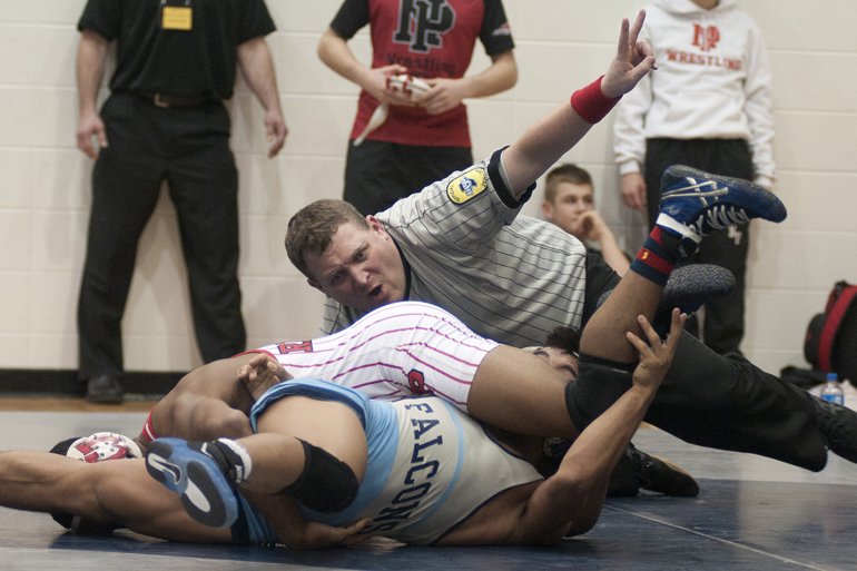 Referee Brandon Shramek calls out points for the championship match at 126 lbs. between Chad Red of New Palestine and Ngun Uk of Perry Meridian during a high school wrestling regional meet at Perry Meridian High School, Saturday, Feb. 7, 2015.