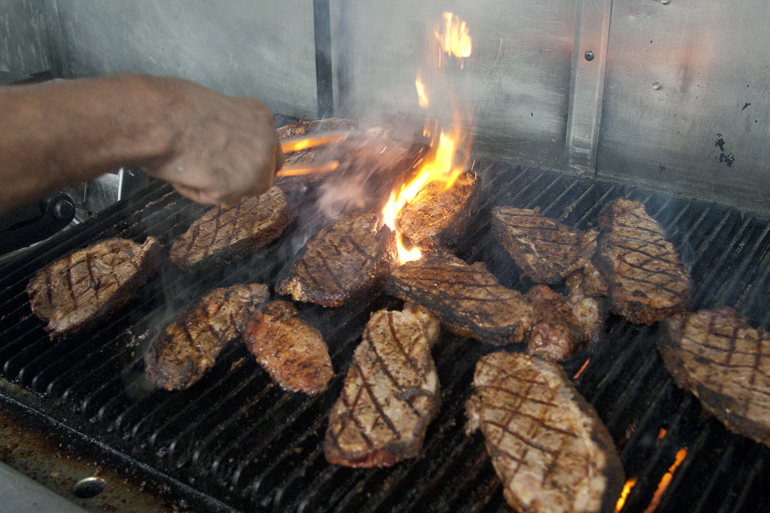 Steaks grill in the kitchen before a private event at Georgia Reese\'s Southern Table & Bar at 86th and Michigan Streets, Saturday, Aug. 30, 2014. The restaurant, set to serve soul food staples in a Prohibition-era supper club atmosphere, opens to the public on Sept. 2.