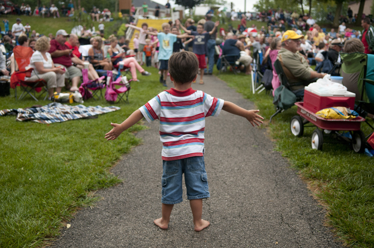 Joshua Wilson, 3, stands in the way of dancing children marching down a path during a Greenwood Summer Concert Series event at the Greenwood Amphitheater, Saturday, July 20, 2013.