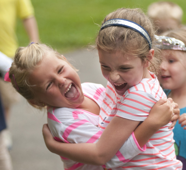 Addi Siner, 5, and Natalie Vance, 5, hug during a Greenwood Summer Concert Series event at the Greenwood Amphitheater, Saturday, July 20, 2013.