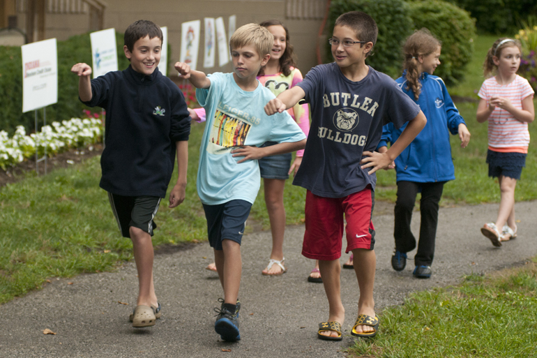 Children march along a path during a Greenwood Summer Concert Series event at the Greenwood Amphitheater, Saturday, July 20, 2013.