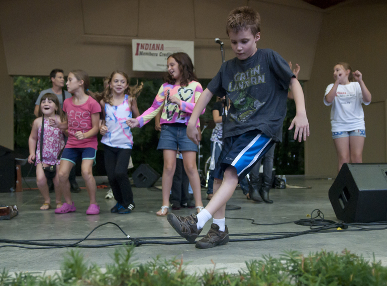 Lucas Reiberg, 7, dances in front of other children on stage during a Greenwood Summer Concert Series event at the Greenwood Amphitheater, Saturday, July 20, 2013.