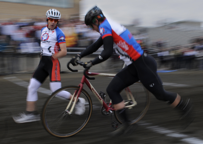 Senior Brian Holthouse of Gray Goat Cycling hands off the bike to senior Zach Trogdon during the first session of Little 500 qualifications Saturday at Bill Armstrong Stadium.