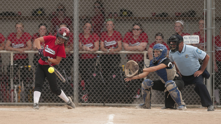 New Palestine left-fielder Markie Wood hits the ball as her team watches from the dugout during the first inning of the Sectional 13 softball championship game at Franklin Community High School, Wednesday, May 28, 2014.