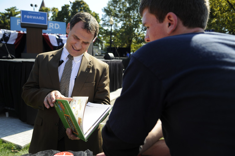 A Secret Service agent flips through OSU junior Lucas Perie's Sesame Street book, which he hoped to have Obama sign.
