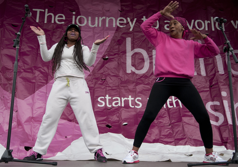 Studio B leader Gina B., together with Beatrice Heard, leads supporters in zumba before the Making Strides Against Breast Cancer 5K walk downtown, Saturday, Oct. 26, 2013.
