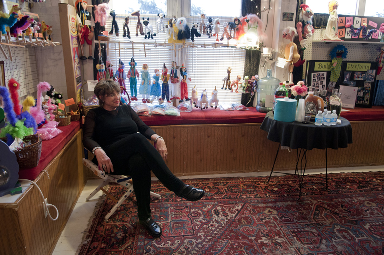 Peggy Melchior, mother of Peewinkle Puppet Studio co-owner Heidi Shackleford, sits in front of puppets on display before Peewinkle\'s annual adult show in Indianapolis, Friday, June 7, 2013.