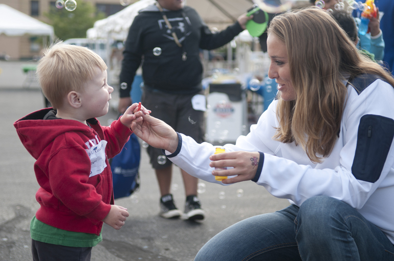 Levi Riddle, 23 months, tries to blow bubbles with Notre Dame softball player Karley Wester during the Riley Hospital for Children Neonatal Intensive Care Unit Reunion at Fairbanks Hall, Saturday, Sept. 13, 2014.