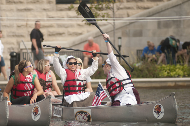 Lentulo Spiralz cheer before the start of the fifth heat of the IUPUI Regatta in the Downtown Canal, Saturday, Sept. 20, 2014. In the regatta, teams race up and down the canal from the head at Fairbanks Hall to the Walnut Street basin and back. Two of a team\'s four rowers paddle from the start line, then exchange the canoe with the other two team members at the basin.