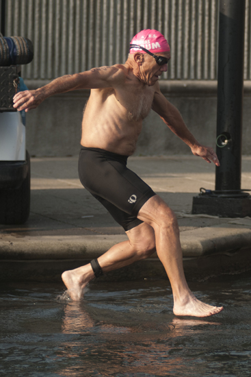 A swimmer jumps into the Indiana Central Canal to begin the Tri-Indy Triathlon, Sunday, Aug. 3, 2014. The triathlon route was centered at White River State Park and went as far north as the Major Taylor Velodrome.