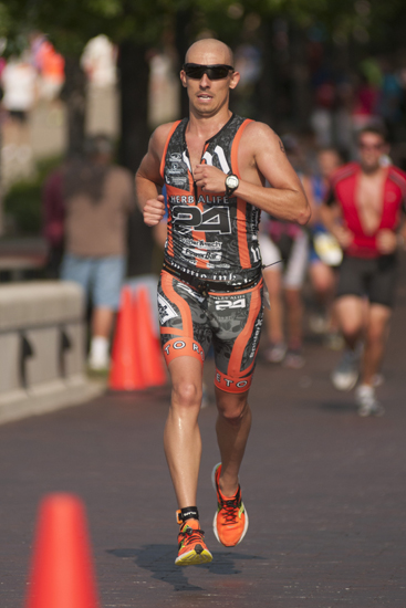 A runner races toward the finish line during the Tri-Indy Triathlon, Sunday, Aug. 3, 2014. The triathlon route was centered at White River State Park and went as far north as the Major Taylor Velodrome.