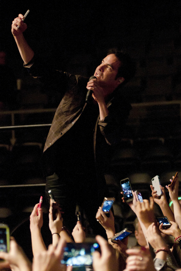 Train lead vocalist Pat Monahan takes selfies with the audience using their phones during the WZPL Jingle Jam at the Indiana Farmers Coliseum, Sunday, Dec. 7, 2014.