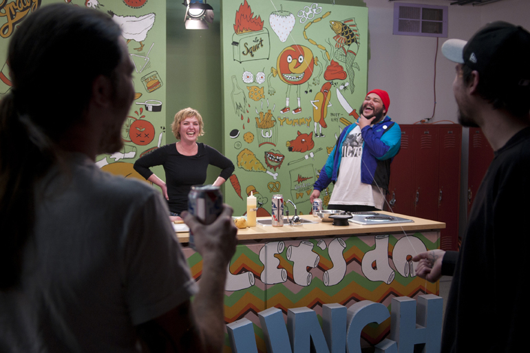 Bluebeard head chef Abbi Merriss and host Oreo Jones laugh while choreographing a bit involving a floating Nigerian prawn before filming an episode of local cooking show \