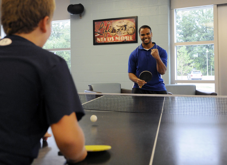 YMCA volunteer Keith Isom celebrates a successful ping-pong volley with Joey while Joey's mother takes a Turbo Kick class at the Hendricks Regional Health YMCA in Avon, Monday, Aug. 13, 2012.